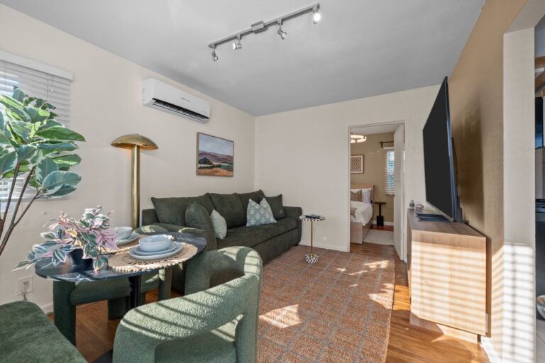 Casa Sol living room with green sofa and 75-inch smart TV